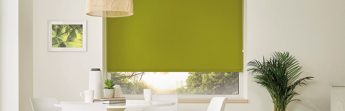 Vibrant green blockout blinds in a sunny dining area, perfect for keeping cool during summer.