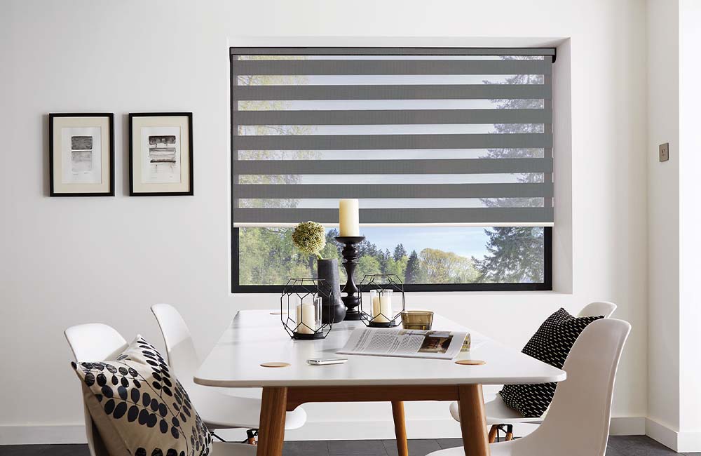 Modern motorised blinds in a bright dining area with a stylish table and neutral decor.