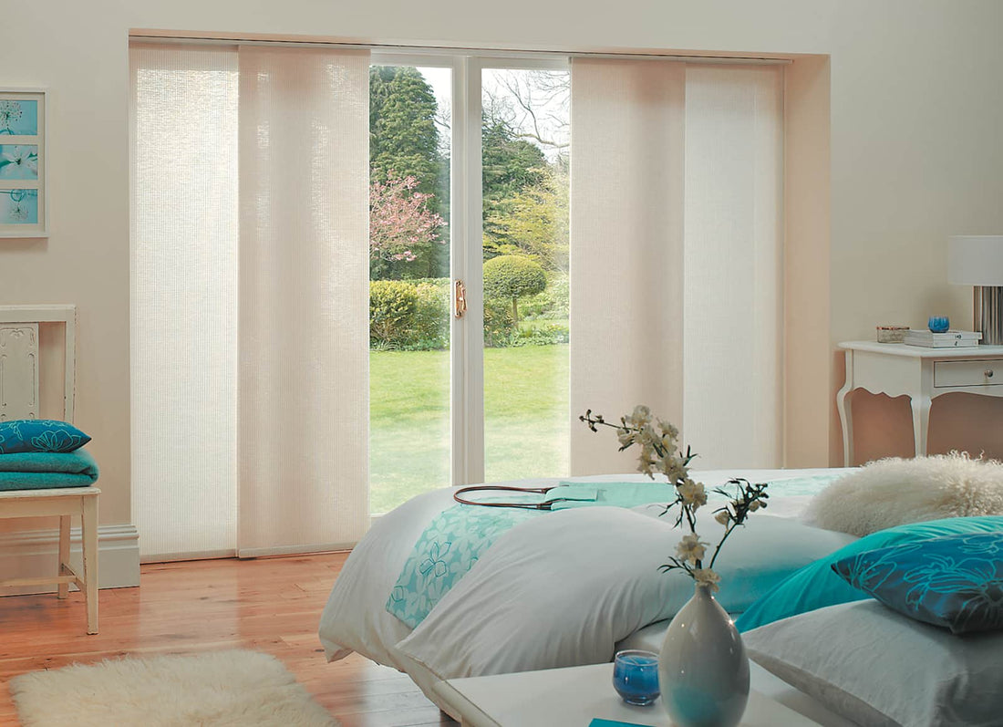 Spacious bedroom featuring thermal blinds on large patio doors, providing elegance and enhanced insulation.