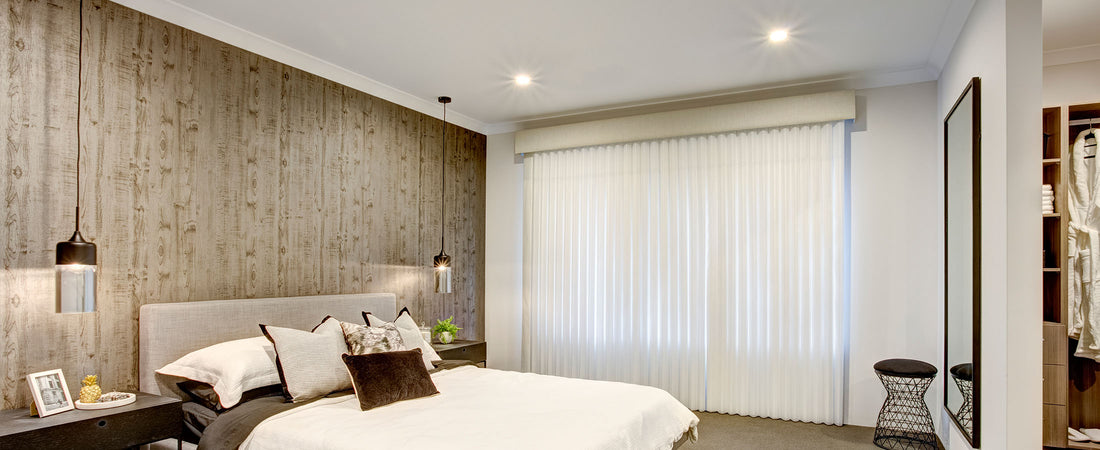 Bright bedroom featuring a stylish bed and large vertical sheer curtains for natural light filtration.