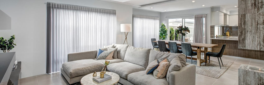 Modern living room featuring sheer curtains, a cozy sectional sofa, and a dining area with elegant decor.