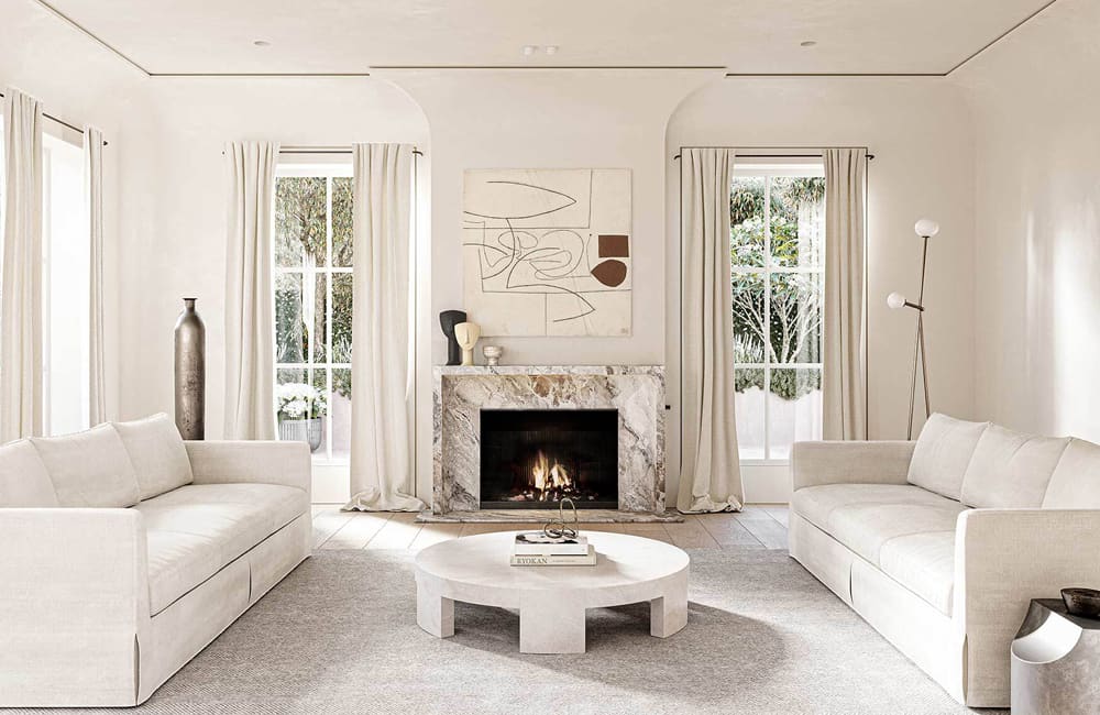 Cozy winter-ready living room with white sofas, a marble fireplace, and natural light from large windows.