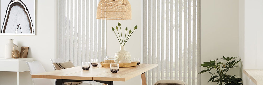 Bright dining room featuring wooden table, stylish pendant light, indoor plants, and sleek vertical blinds.