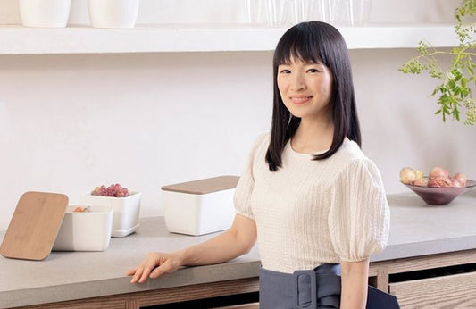 Marie Kondo in a stylish kitchen, promoting organization and decluttering tips.